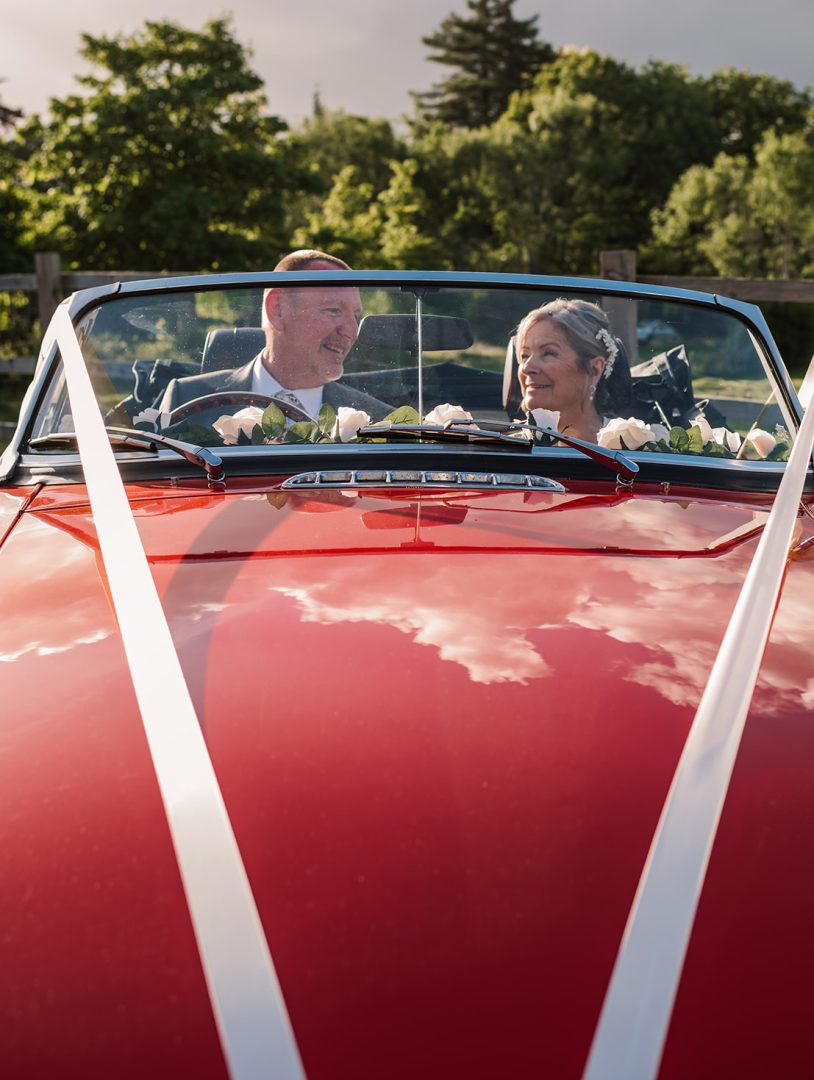 Just marries couple in red car