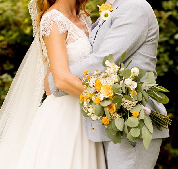 Couple getting marries hugging with bouquet