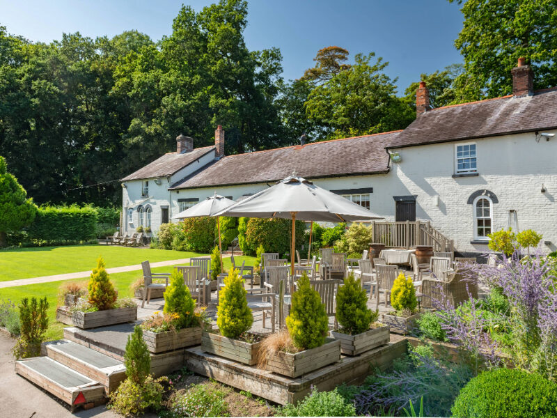 The beautiful garden terrace at Burley Manor, offering an ideal outdoor setting to enjoy drinks, meals, or simply relax while surrounded by the natural beauty of the New Forest. A perfect place to unwind in a tranquil and picturesque environment.