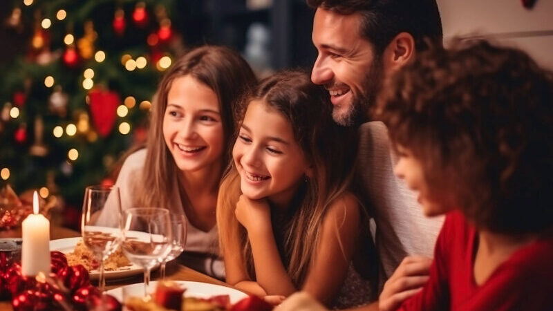 Family gathered in a warm, festive New Forest hotel lounge, sharing Christmas joy with twinkling lights, seasonal decorations, and cosy surroundings—perfect for a magical holiday escape.
