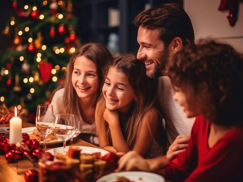 Family gathered in a warm, festive New Forest hotel lounge, sharing Christmas joy with twinkling lights, seasonal decorations, and cosy surroundings—perfect for a magical holiday escape.