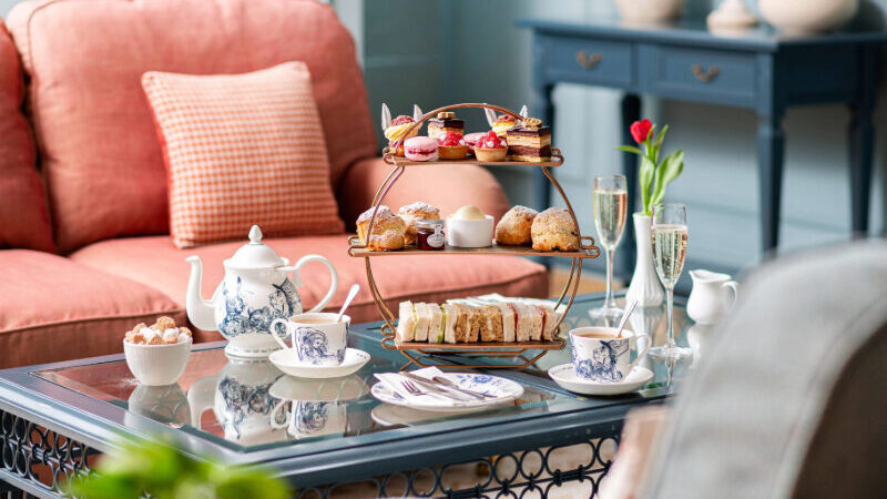 Guests enjoying a traditional afternoon tea at Bartley Lodge, featuring delicate sandwiches, freshly baked scones, and a selection of sweet treats, all served in a charming New Forest setting. Perfect for a relaxing afternoon in the countryside.