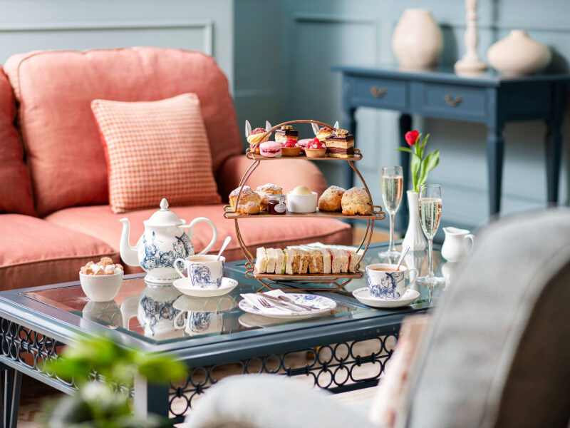Guests enjoying a traditional afternoon tea at Bartley Lodge, featuring delicate sandwiches, freshly baked scones, and a selection of sweet treats, all served in a charming New Forest setting. Perfect for a relaxing afternoon in the countryside.