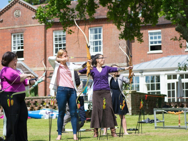 Colleagues engaging in an outdoor team-building activity in the New Forest, surrounded by nature, working together to enhance communication, collaboration, and morale in a beautiful, natural setting.